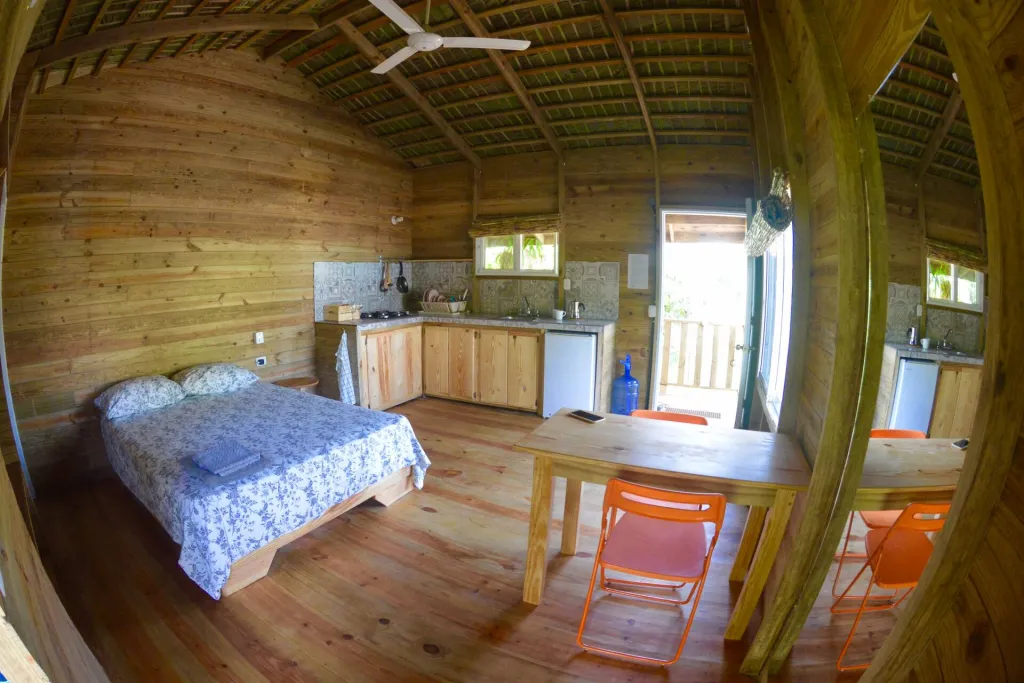 Wooden loft with a bed, table and balcony door