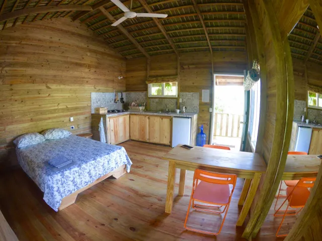 Wooden loft with a bed, table and balcony door