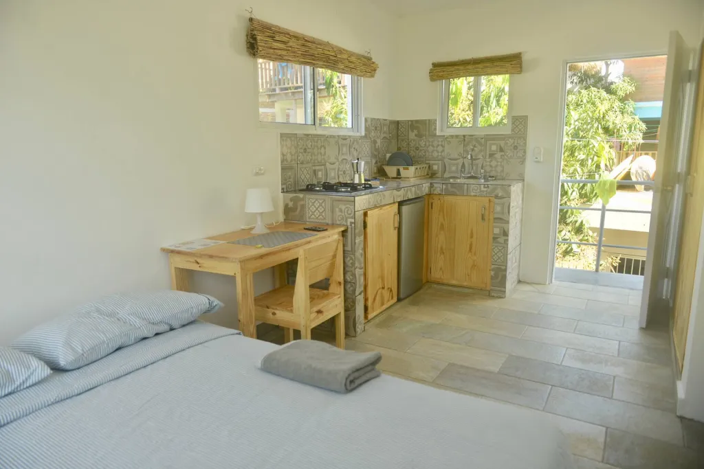 Bed, desk and kitchen counter in a bright studio