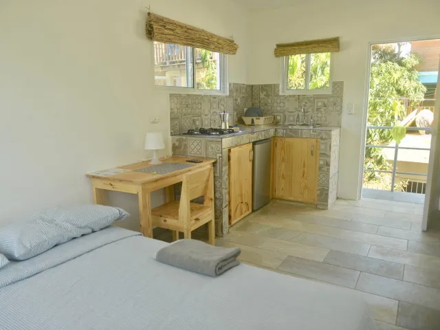 Bed, desk and kitchen counter in a bright studio