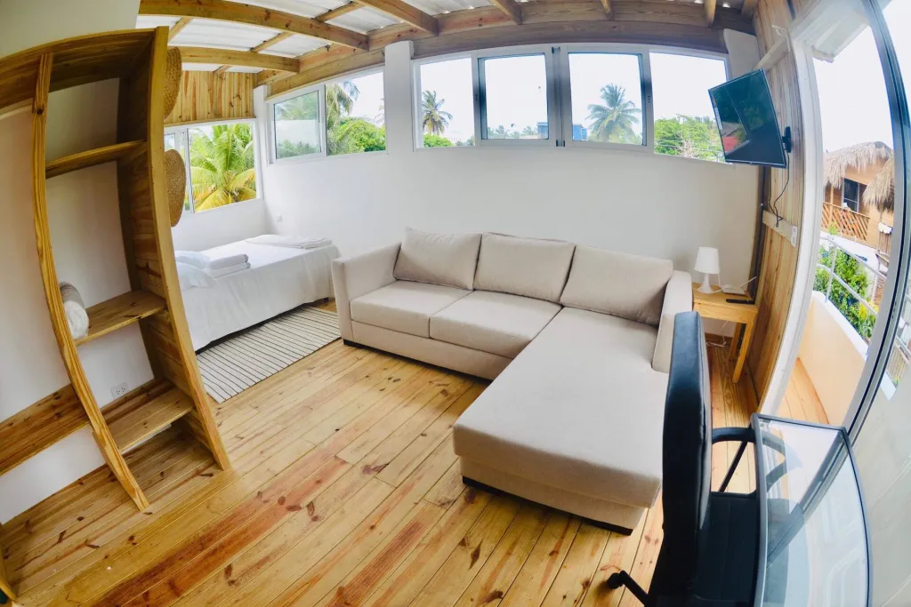 Bright wooden penthouse with a sofa, bed and windows all round