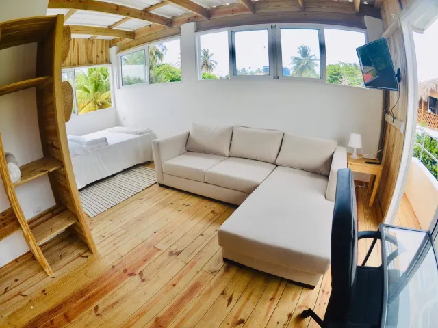 Bright wooden penthouse with a sofa, bed and windows all round